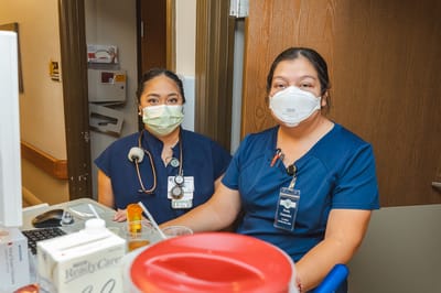Two healthcare staff members smiling in a care facility