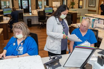 Staff members collaborating at the nursing facility front desk