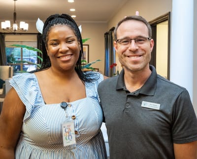 Staff member and resident smiling in a common area
