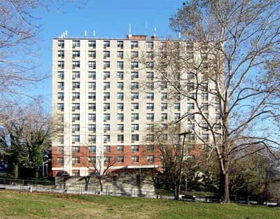 Exterior view of Woodstock Manor building surrounded by trees