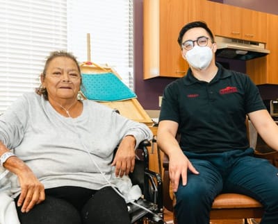 Resident and staff member in a comfortable facility interior
