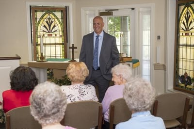 A staff member speaking to a group of residents in a common area
