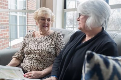 Two residents chatting in a cozy common area