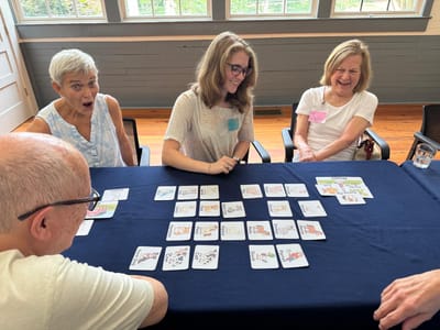 Residents and staff enjoying a card game around a table