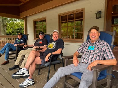 Four residents enjoying chairs on a porch