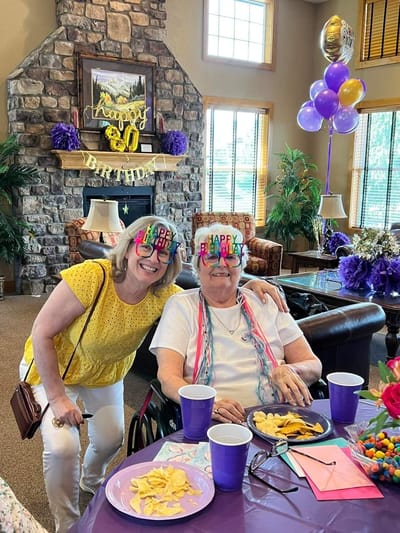 Residents celebrating a birthday in a decorated common area