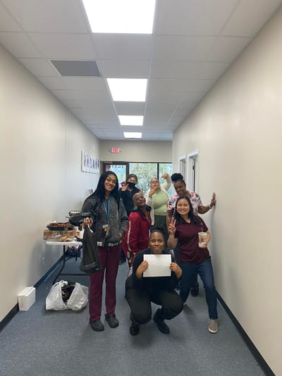 Staff and residents celebrating in a bright hallway