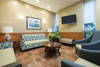 Bright common area with comfortable seating and floral decor