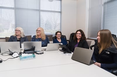 Staff members in a meeting room with laptops