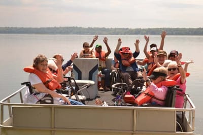 Residents enjoying a boat ride with staff on a sunny day