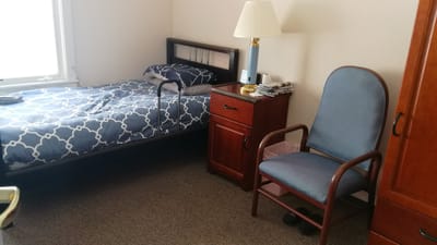 Cozy resident room with a bed and chair