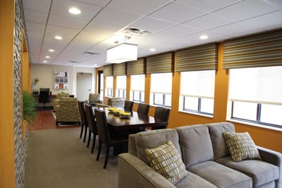 Brightly lit common area with dining table and seating