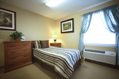 Cozy resident room with bed and furniture
