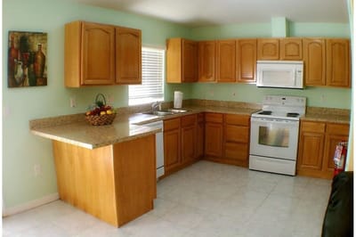 Bright kitchen area with wooden cabinets and appliances