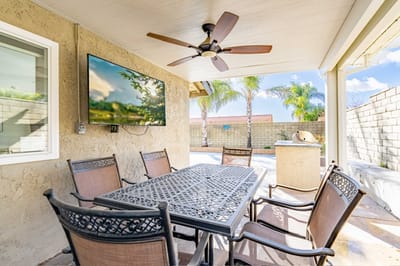 Outdoor patio area with seating and a TV