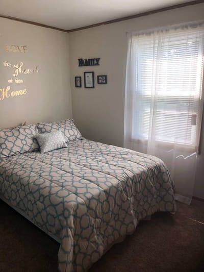 Cozy bedroom with a patterned bedspread and family decor