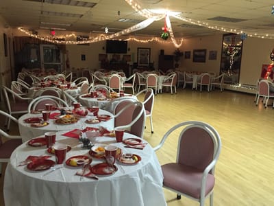 A dining room set for a festive meal with tables and decorations