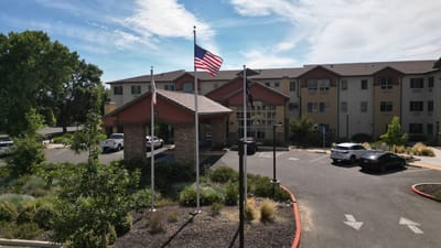 Front entrance of The Woodlake Senior Living facility with flags