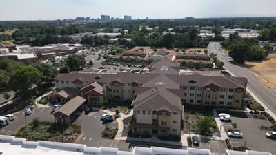 Aerial view of a senior living facility with surrounding trees
