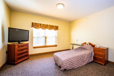 A private resident room with bed and furniture