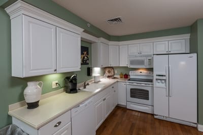 Bright kitchen with white cabinetry and appliances