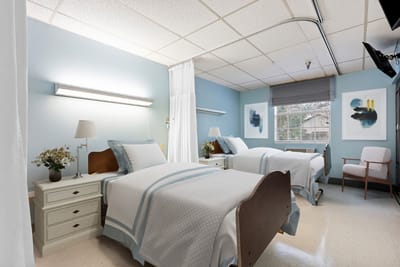 A shared resident room with two beds and seating area