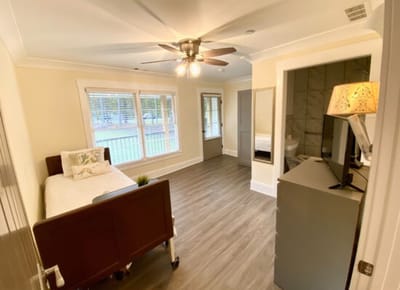 Bright, spacious private resident room with a bed and window
