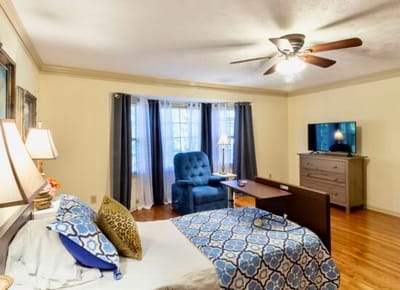 Cozy interior of a resident's room with a bed and seating area