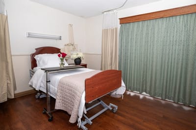 Interior of a patient room with flowers on the bedside