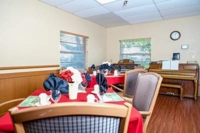 Dining room setup with red tablecloths and floral centerpieces