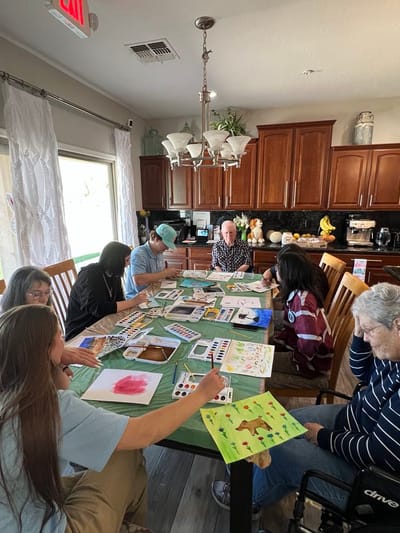 Residents engaged in a painting activity around a table