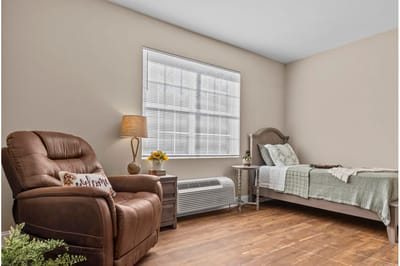 Private resident room with a chair and bed