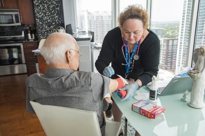 Nurse attending to an elderly patient in a bright room