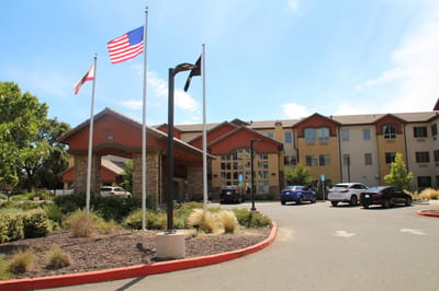 Exterior view of The Woodlake Senior Living entrance with flags