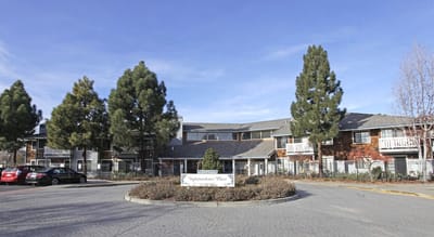 Exterior view of Independence Plaza with trees and parking