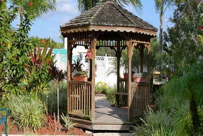 Wooden gazebo surrounded by vibrant garden