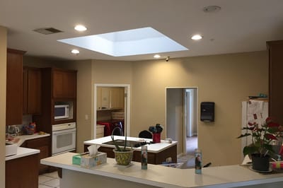 A kitchen area with light fixtures and cabinets