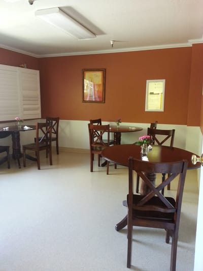 A warm and inviting common area with tables and flowers