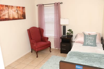 Cozy private resident room with a bed and chair