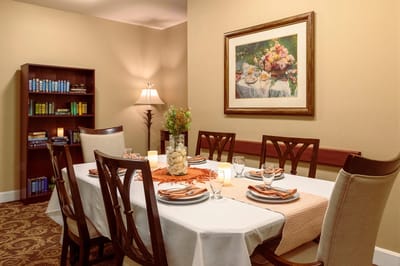 Dining room setup with a floral painting and table setting