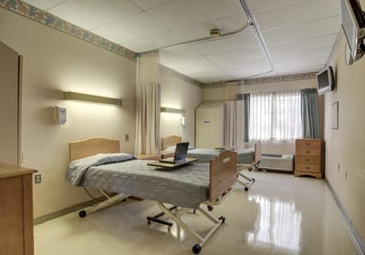 A shared resident room with two beds and a window