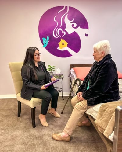 A caregiver interacting with a senior resident in a cozy room