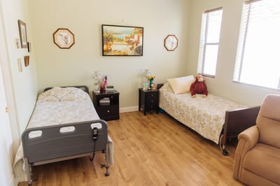 Private resident room with two beds and a decorative wall