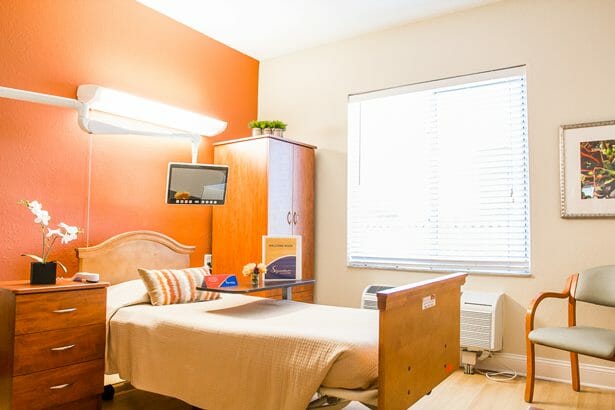 Bright and clean private resident room with bed and furniture