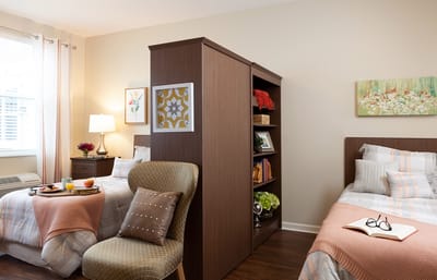 Bright, shared resident room with two beds and breakfast tray