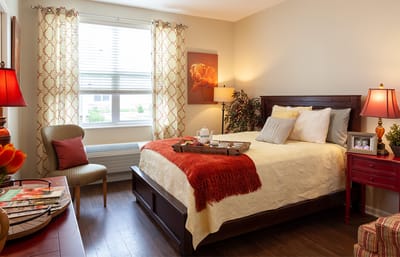 A well-furnished private resident room with a bed and decor
