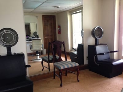 Interior view of a hair salon area with chairs and mirrors