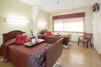 A shared resident room with two beds and natural light