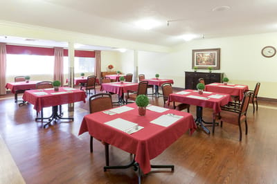 Dining room set up for residents with red tablecloths