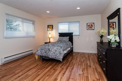 Well-furnished resident bedroom with wooden floor